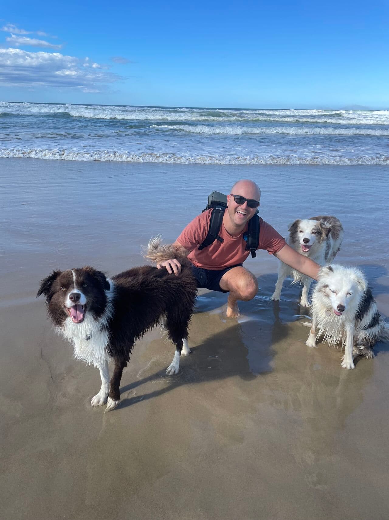 Kyle with rescue dogs at the beach
